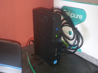 A Dell N06D thin client, a USB 3.0 hub and two 2.5" SATA caddies cable tied together.