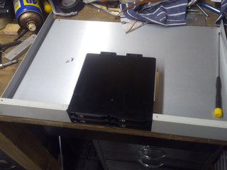 Enclosure with section of front panel cut out for hard drive backplane